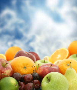 Large selection of fresh fruit against a blue sky background